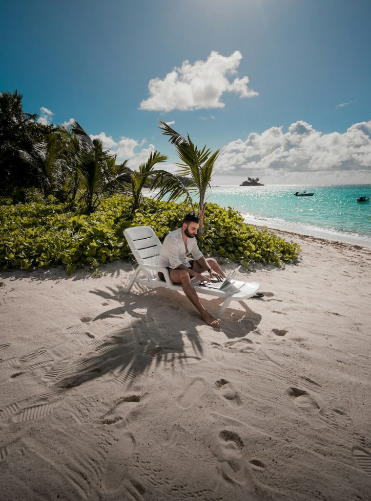 Demo Post 2 Working on my laptop by the beach on an island sitting on a long chair under the sun